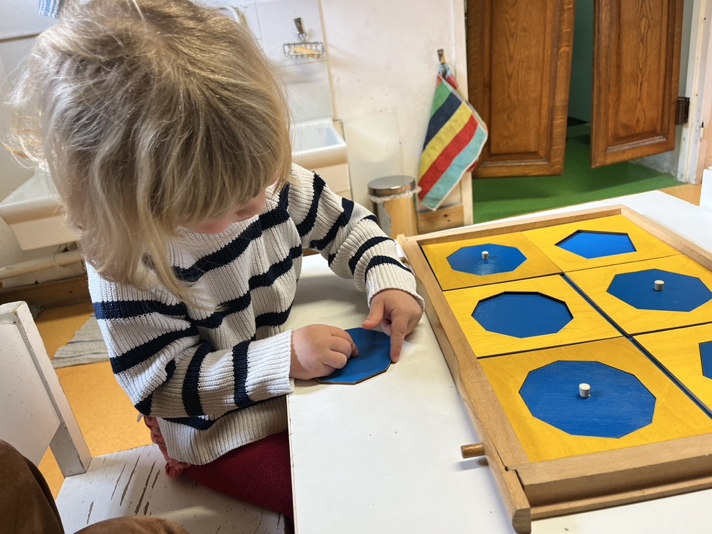 Enfant explorant un matériel sensoriel de formes