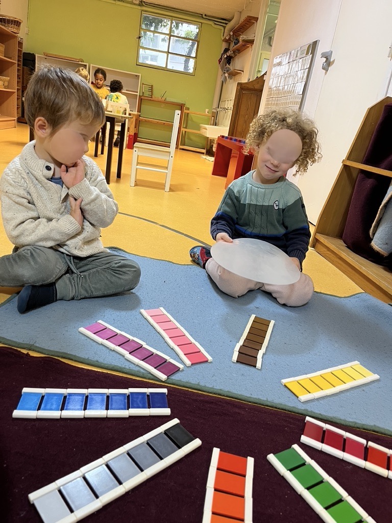 Deux enfants travaillent avec du matériel Montessori dans la classe
