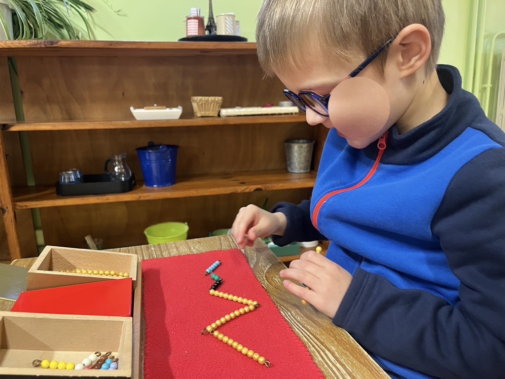 Enfant manipulant du matériel de mathématiques Montessori