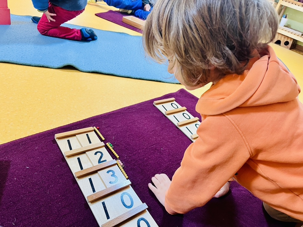 Enfant concentré sur une activité de mathématiques Montessori